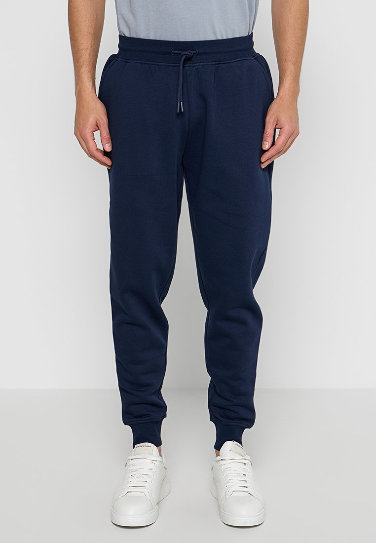 Pantaloni jogger blu navy realizzati in morbido tessuto, con vita elasticizzata e cordoncino, polsini aderenti e tasche laterali.