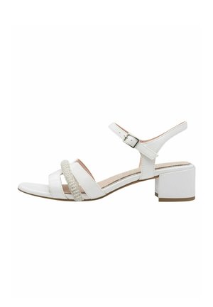 Weiße Sandale mit Blockabsatz, ausgestattet mit überkreuzten Riemen und einem strukturierten Riemen mit kleinen Verzierungen. Verstellbare Schnalle am Knöchel.