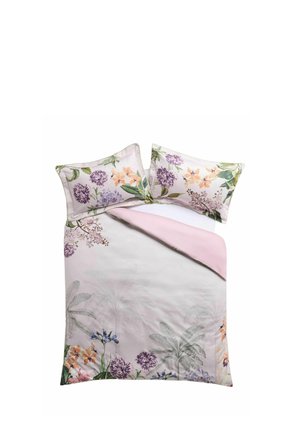 Letto matrimoniale con copripiumino floreale rosa e cuscini coordinati con disegni botanici viola, arancione e verde su sfondo chiaro.