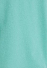 Texture de tissu en turquoise clair uni, lisse avec des détails subtils de tissage, de couleur uniforme avec un éclairage doux.