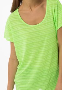 Neon grön kortärmad t-shirt med avslappnad passform, med subtila horisontella linjer och bred rundad halsringning. Mjuk, lätt väv.