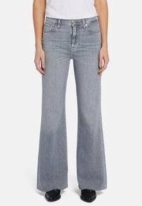Jeans évasés gris clair en denim avec une texture délavée, comportant cinq poches, une fermeture à zip et des détails d'ourlet brut.
