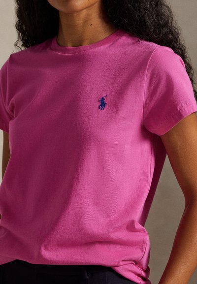 Ροζ βαμβακερό t-shirt με κοντά μανίκια, διακοσμημένο με μπλε κεντημένο λογότυπο στο στήθος, με άνετη γραμμή και απαλό ύφασμα.