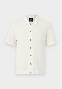 Polo en tricot blanc cassé avec un motif texturé, manches courtes, fermé par des boutons contrastés, et un col plat.