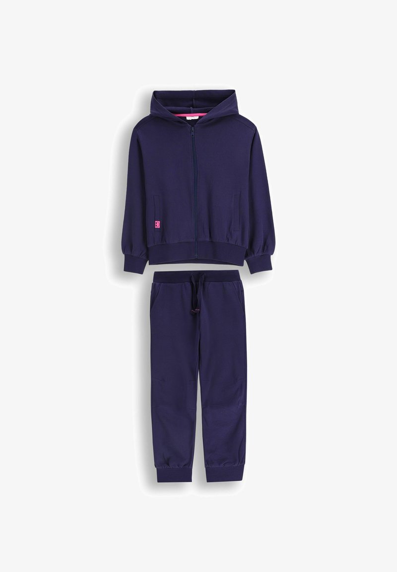 Granatowa bluza z zamkiem i różowymi akcentami oraz kieszeniami, zestawiona z dopasowanymi spodniami z elastycznym pasem i zwężanymi mankietami.