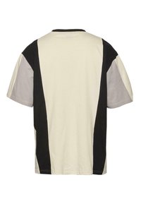 Short-sleeve t-shirt featuring a color-block design in cream, black, and gray. Made of soft cotton with a round neckline and relaxed fit.