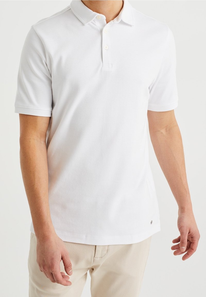 Weißes Kurzarm-Poloshirt aus weicher Baumwolle mit klassischem Kragen, drei Knöpfen und kleinem Logo near dem Saum.