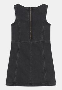 Vestido de mezclilla negro sin mangas con costuras visibles y una cremallera en la parte posterior centrada que se extiende desde el escote hasta la cintura.