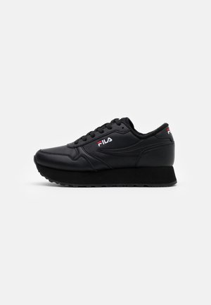 Baskets noires FILA avec semelle épaisse, lacets à l'avant, logo brodé sur le côté et le talon, vues de profil gauche sur fond blanc.