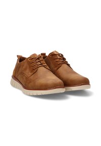 Zapatos de cuero marrón con cordones, de textura suave, puntera redondeada y suela de goma blanca contrastante. Diseño casual con detalles mínimos.