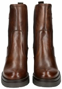Bottines en cuir marron avec des panneaux élastiques sur le côté, une texture lisse et une semelle en caoutchouc noir robuste pour la durabilité et le soutien.