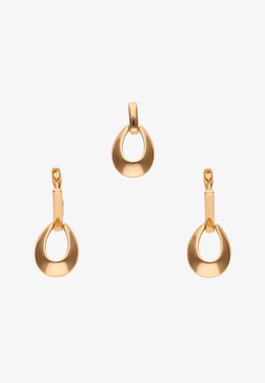 Arany tónusú, csepp alakú medál és hozzáillő arany tónusú csepp alakú karika fülbevalók fehér háttéren.