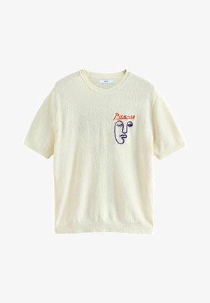 T-shirt court crème à manches courtes texturé avec col rond et design abstrait brodé d'un visage en violet et rouge avec le texte « Picasso » sur le côté gauche de la poitrine.