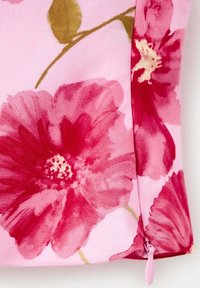 Tissu rose avec de grandes fleurs rouges et magenta ainsi que des feuilles vertes, avec un petit curseur de fermeture éclair rose en bas.