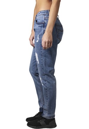 Blue denim jeans with a relaxed fit, featuring distressed areas and a classic five-pocket design, worn with black sneakers.