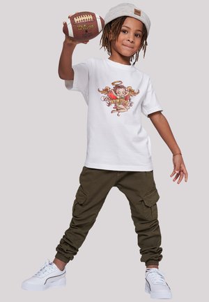Weißes T-Shirt mit einem bunten Grafikdesign, grüne Cargo-Hosen und weiße Sneakers. Das Kind hält einen Fußball und trägt eine hellgraue Mütze.