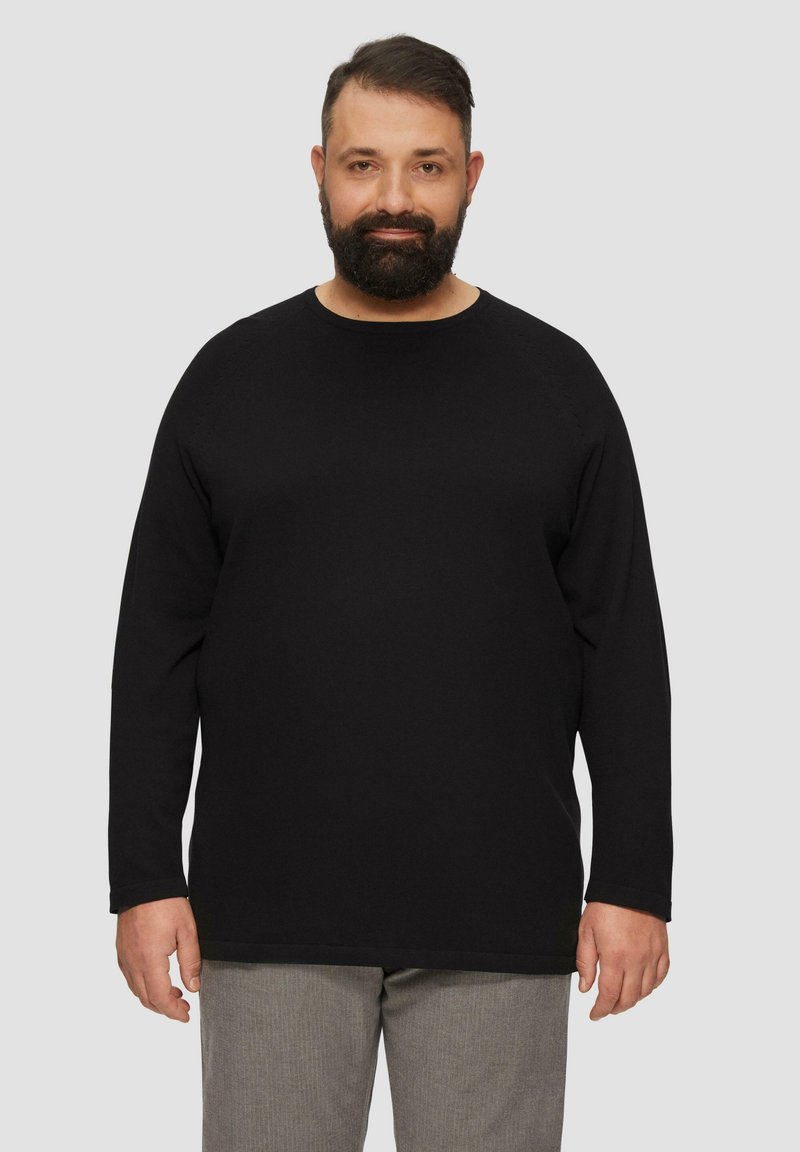 Zwarte longsleeve T-shirt met een ronde hals, gemaakt van textuurstof. Heeft een ontspannen pasvorm en rechte zoom, gedragen met grijze geblokte broek.