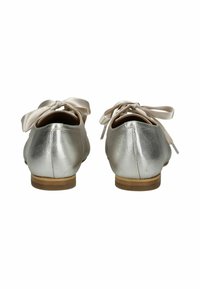 Ballerine in pelle argentata con superficie liscia, caratterizzate da punta rotonda e un fiocco di satin sul retro. Tacco basso in legno, design minimal.