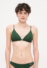 Ensemble de bikini vert avec une texture côtelée, bralette triangulaire à fines bretelles et détail à double sangle, accompagné d'un bas côtelé assorti.