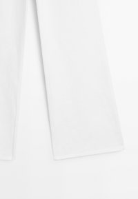 Bílé kalhoty s širokými nohavicemi vyrobené z texturované látky. Mají čistý, minimalistický design s rovnými švy a hladkým lemem.