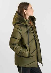 Dikke groene jas met een capuchon, getailleerd ontwerp en zwarte trekkoorden; heeft zijzakken en een ritssluiting.