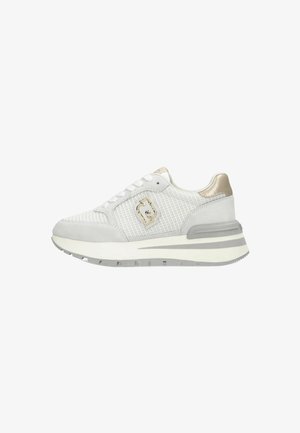 Zapatilla deportiva blanca con una parte superior de malla texturizada, acentos de ante gris y un detalle metálico dorado. Presenta una suela gruesa y acolchada.