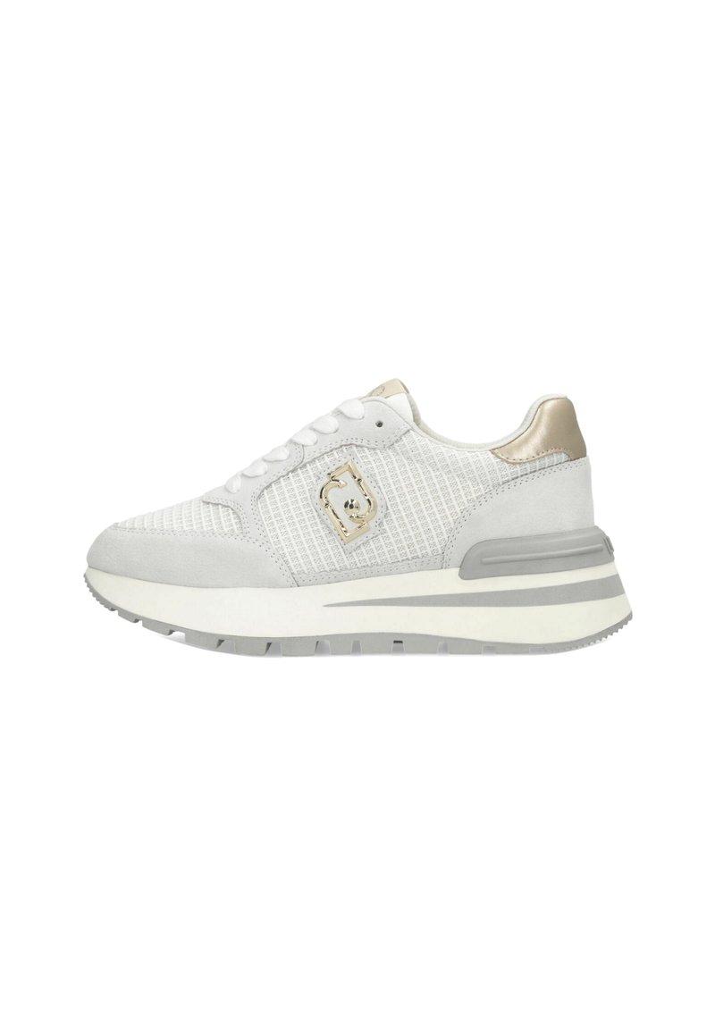 Zapatilla deportiva blanca con una parte superior de malla texturizada, acentos de ante gris y un detalle metálico dorado. Presenta una suela gruesa y acolchada.