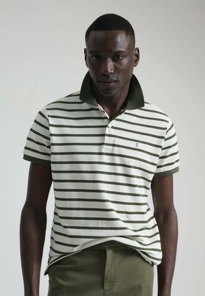 Camiseta polo a rayas con rayas horizontales verdes y blancas, cuello verde, mangas cortas, tapeta de tres botones y un sutil detalle de logo.