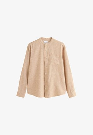 Beżowa koszula na długi rękaw zapinana na guziki z kołnierzem mandaryńskim i kieszenią na piersi, z fakturowanej tkaniny, ułożona na płasko na białym tle.