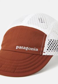 Rustrød og hvid mesh Patagonia kasket med buet skygge og broderet brandlogo på frontpanelet, fotograferet på hvid baggrund.