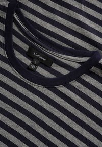 Tamsiai mėlyna ir šviesiai pilka dryžuota marškinė su apvaliu iškirpimu. Pagaminta iš minkštos medžiagos, turi etiketę su "Matinique" ir dydžiu "L".