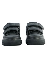 Zapatillas negras con tres cintas de velcro, material de cuero y malla, suela de goma texturizada y diseño de punta redondeada.