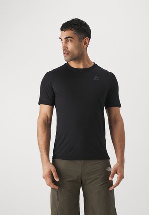 Black short-sleeve t-shirt made of lightweight fabric with a round neckline; features a small logo on the chest. Worn with olive green pants.