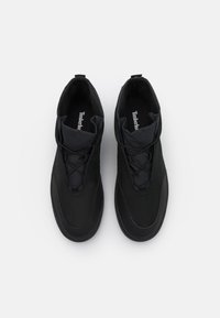 Černé sportovní boty s elegantním designem, které mají hladký syntetický svršek, elastické šňůrky a polstrovaný límec pro pohodlí.