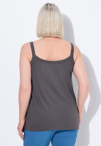Canotta grigia senza maniche con scollo a barca, realizzata in tessuto morbido. Il design presenta una vestibilità rilassata e dettagli di cucitura delicati.