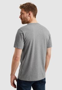 Camiseta gris de manga corta con cuello redondo, confeccionada en algodón suave. Presenta un diseño liso con textura suave y un ajuste relajado.