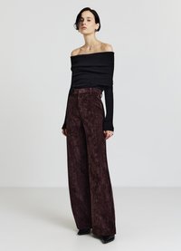 Schwarzes Off-Shoulder-Oberteil kombiniert mit hoch taillierter, weiter Hose aus strukturiertem burgunderrotem Stoff. Das Outfit verfügt über enganliegende Ärmel und einen Knopfverschluss.