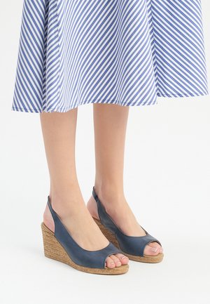 Morske modre klinaste sandale z odprto konico, z zasnovo peep in teksturiranim jute klinom. Elegantna materiala z gladko površino.