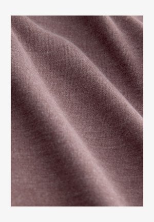 Pehme, tekstuuriga kangas summutatud lilla toonis, näidates kudumises õrnu variatsioone. Taust on hägune, rõhutades materjali detaili.