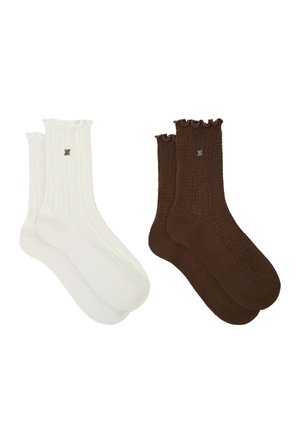 Dos pares de calcetines de canalé con puños fruncidos, un par blanco y un par marrón, cada uno con un pequeño logo decorativo.