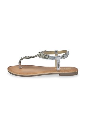 Sandale en thong argentée avec des détails en perles décoratives et une semelle plate marron. Présente une bride réglable au niveau de la cheville et un design minimaliste.