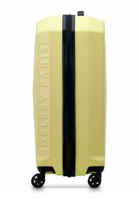 Valigia rigida di colore giallo chiaro con superficie testurizzata, cerniera nera e dettagli neri. Dotata di quattro ruote per la mobilità. Nome del marchio impresso.