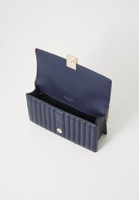 Navy blue leather wallet with a quilted design, gold hardware clasp, and interior compartments. Smooth texture and structured shape.