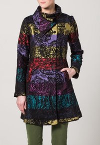 Cappotto multicolore caratterizzato da un motivo testurizzato in nero, rosso, giallo, viola e teal. Ha un colletto, bottoni e tasche laterali.