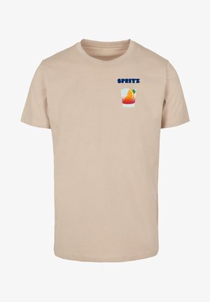 Beige cotton t-shirt featuring a graphic of a cocktail glass with an orange slice and the word "SPRTIZ" in blue above the design.