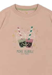 Světle růžové bavlněné tričko s ilustracemi dvou pohárů se pruhovanými brčky, bubble tea a zlatými hvězdami. Nápis zní "VÍCE BUBLIN, MÍN PROBLÉMŮ."