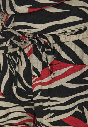 Tissu noir, ivoire et rouge présentant un motif de rayures de zèbre audacieux. La taille comporte un cordon de serrage ajustable pour un bon ajustement. La texture semble légère.