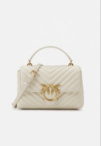 Mala em couro creme acolchoado com um fecho circular dourado decorado com dois pássaros. Inclui uma alça de ombro removível para maior versatilidade.