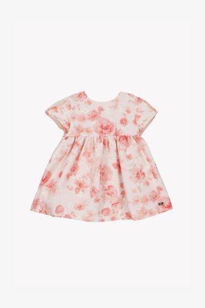 Blomstret kjole med rund halsudskæring og korte ærmer. Lyserødt stof med blomsterprint i nuancer af fersken og koral. Kjolen har et fuldt skørt.