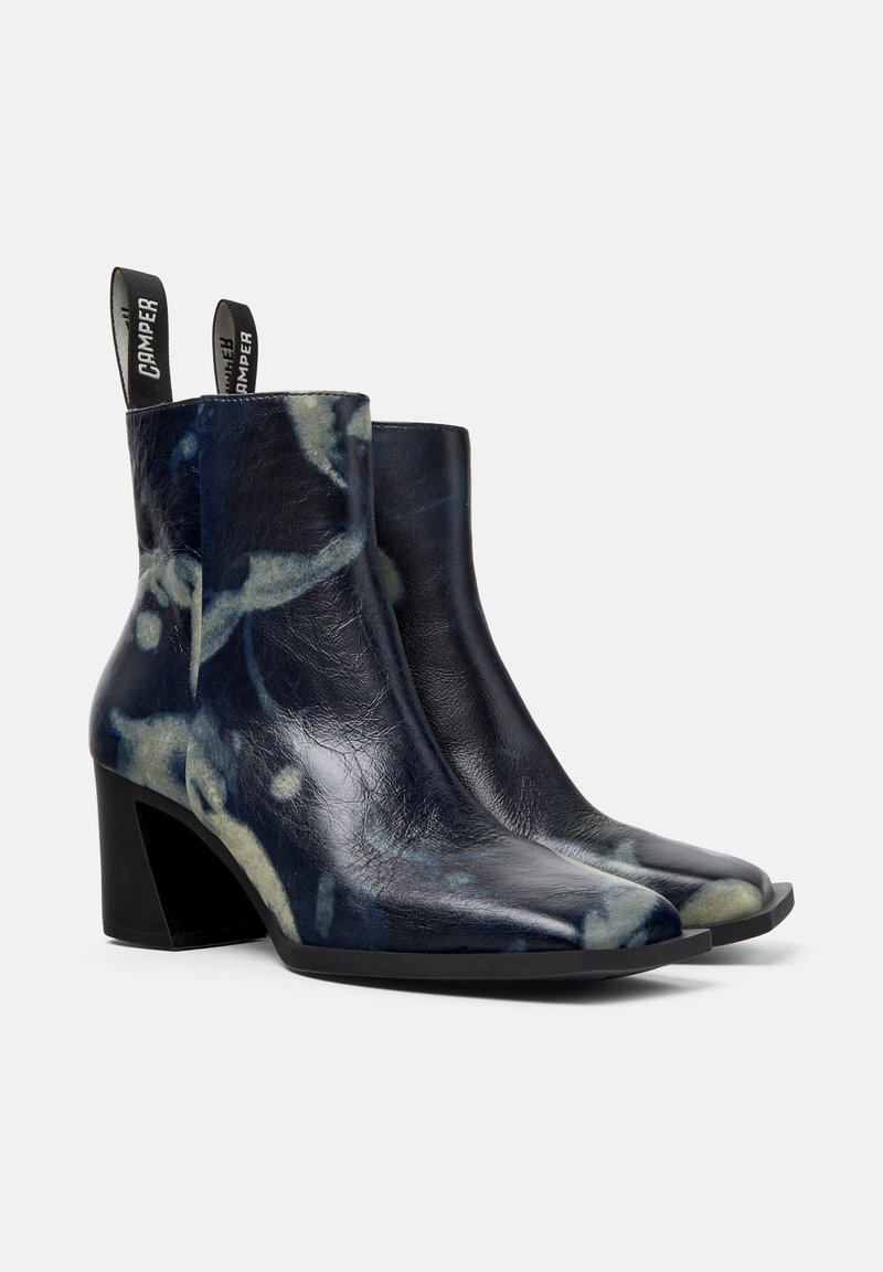 Ankelstövlar i marinblått läder med ett marmoriserat mönster, rundad tå och en kraftig klack. Har dragflikar för enkel påtagning.